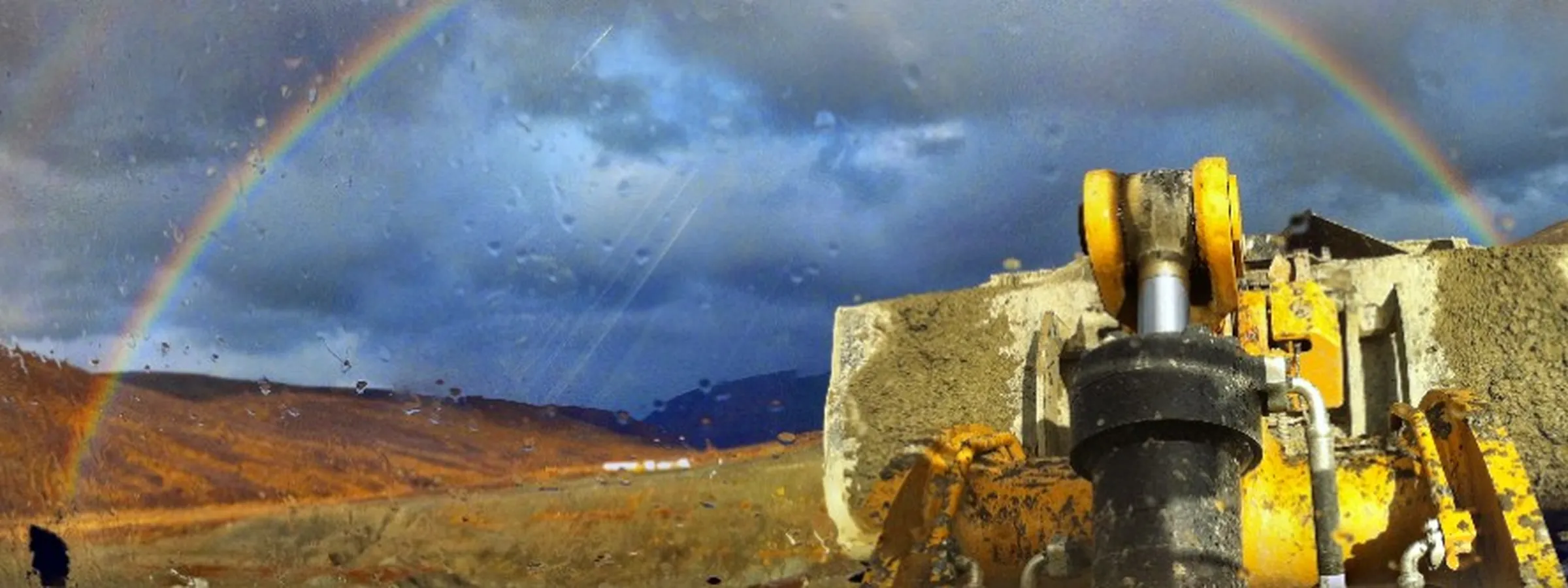 Double rainbow over Alaska tundra from a heavy equipment cab