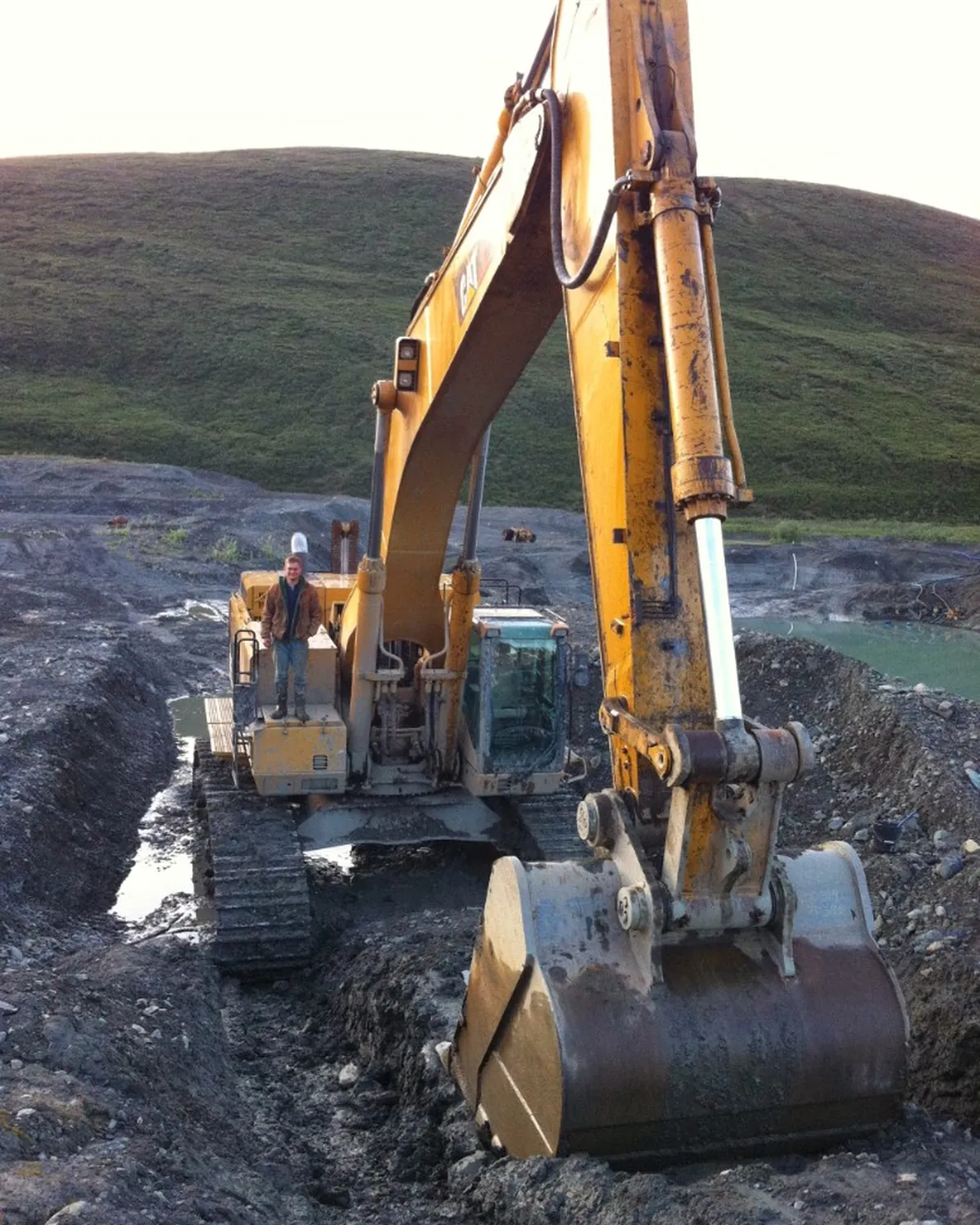 Standing on a Caterpillar 385 excavator at an Alaska mining site